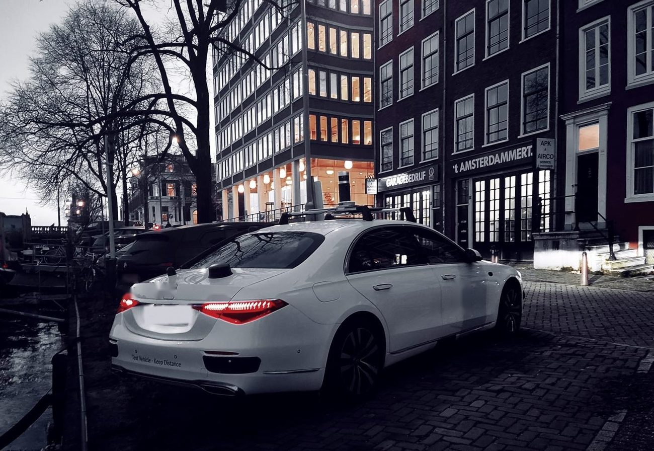 Sensorbestückte Limousine an einer Grachtenstraße in der Dämmerung